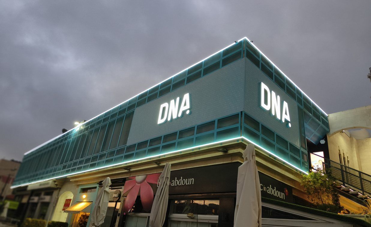 Building facade with steel mesh cladding, LED edge lighting and backlit letters